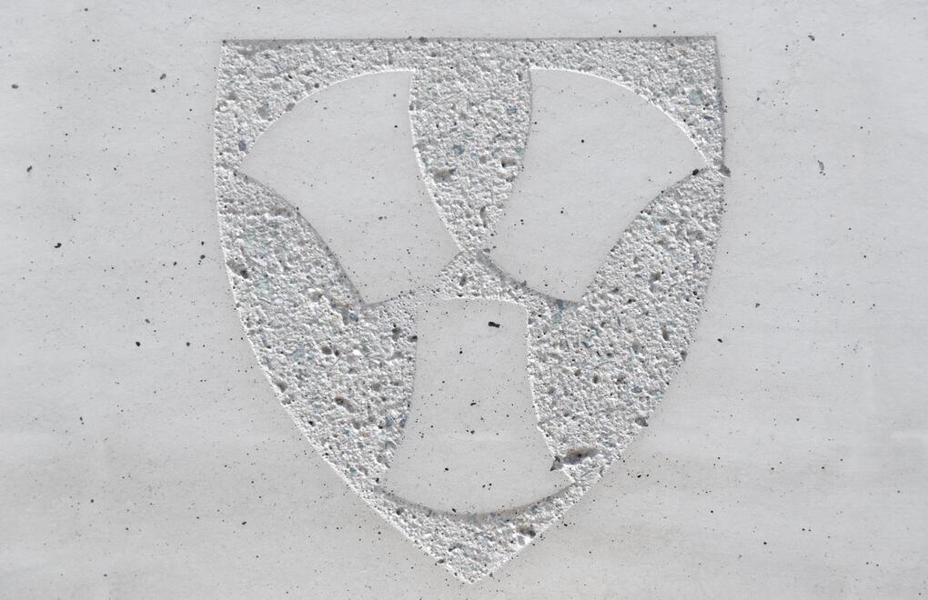 Detail vytryskaného loga obce na betonovém květináči