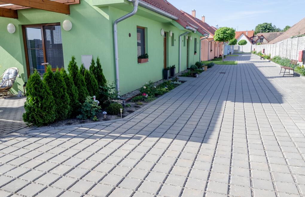 Okolí rodinných domů dlážděné ekologickou vsakovací dlažbou LORA